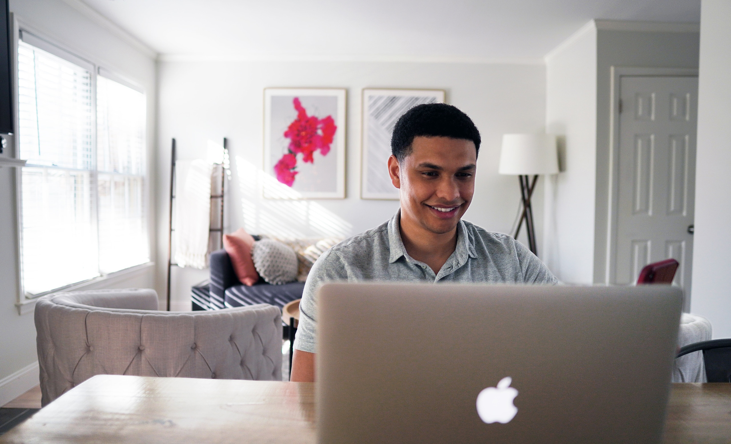 Man looking at the screen of his laptop and smiles