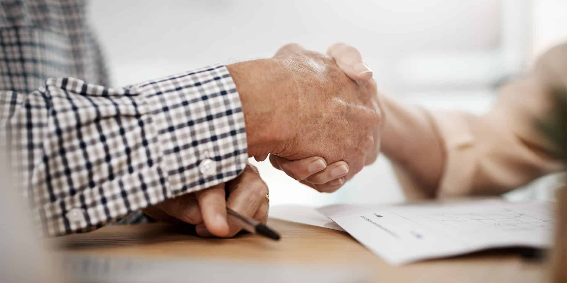 senior man shaking hand with financial advisor